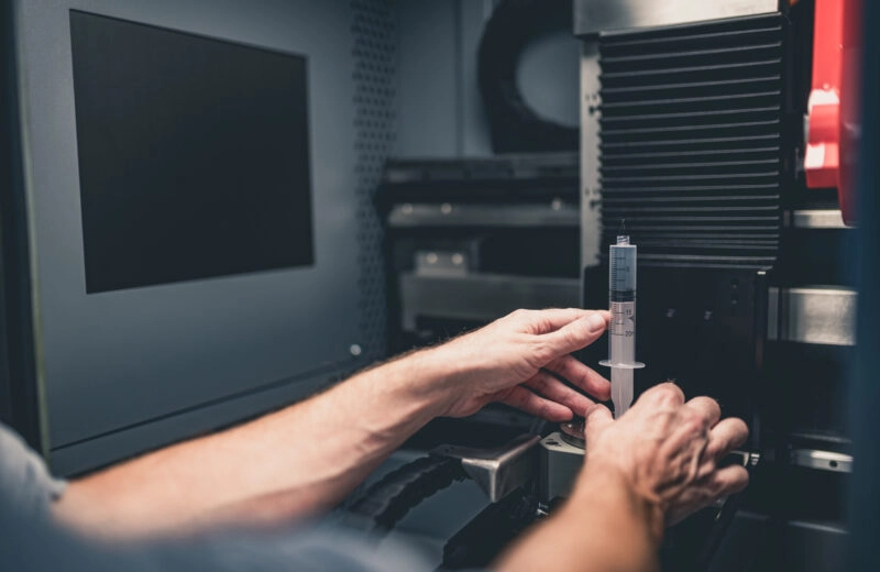 expert chargeant un echantillon dans tomographe