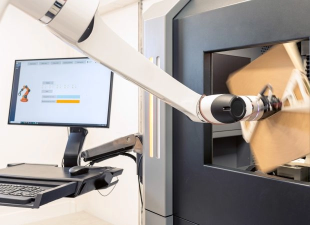 un cobot qui charge un support dans un tomographe
